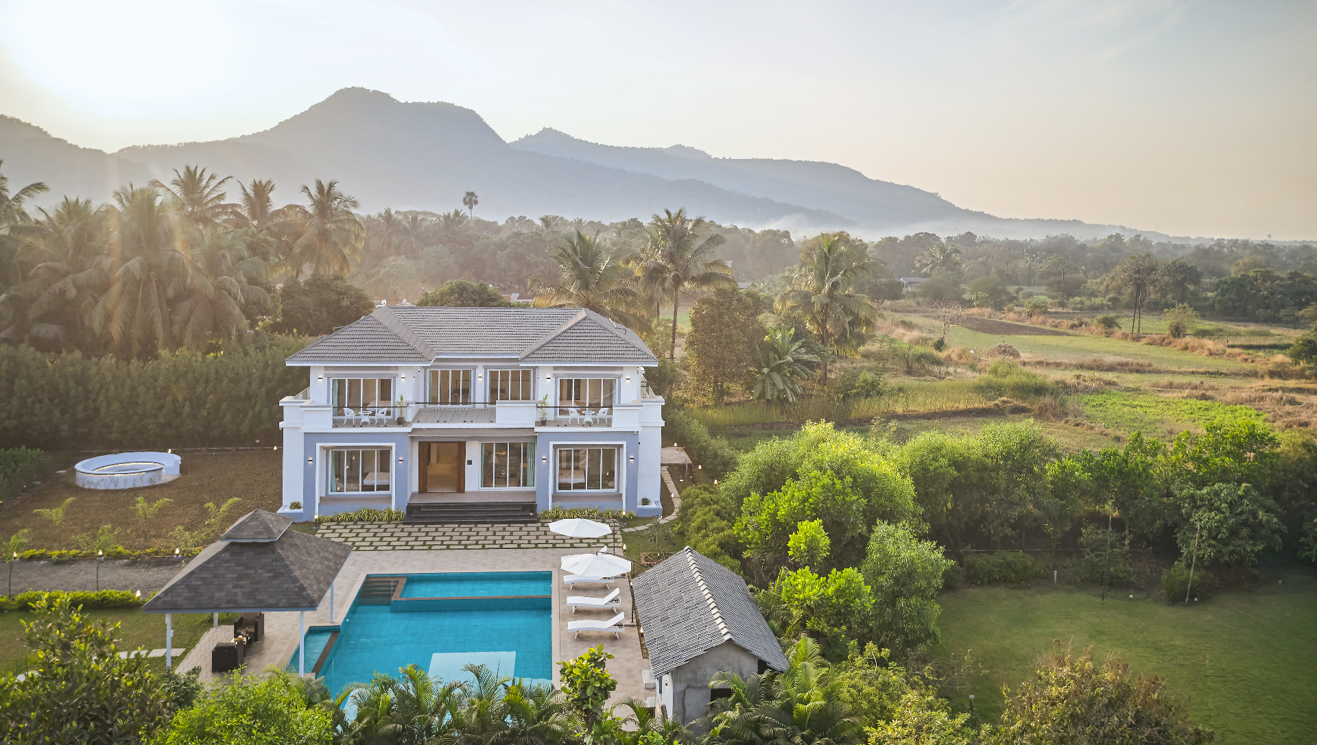A modern Privy Stays villa nestled in lush nature with mountains at sunrise